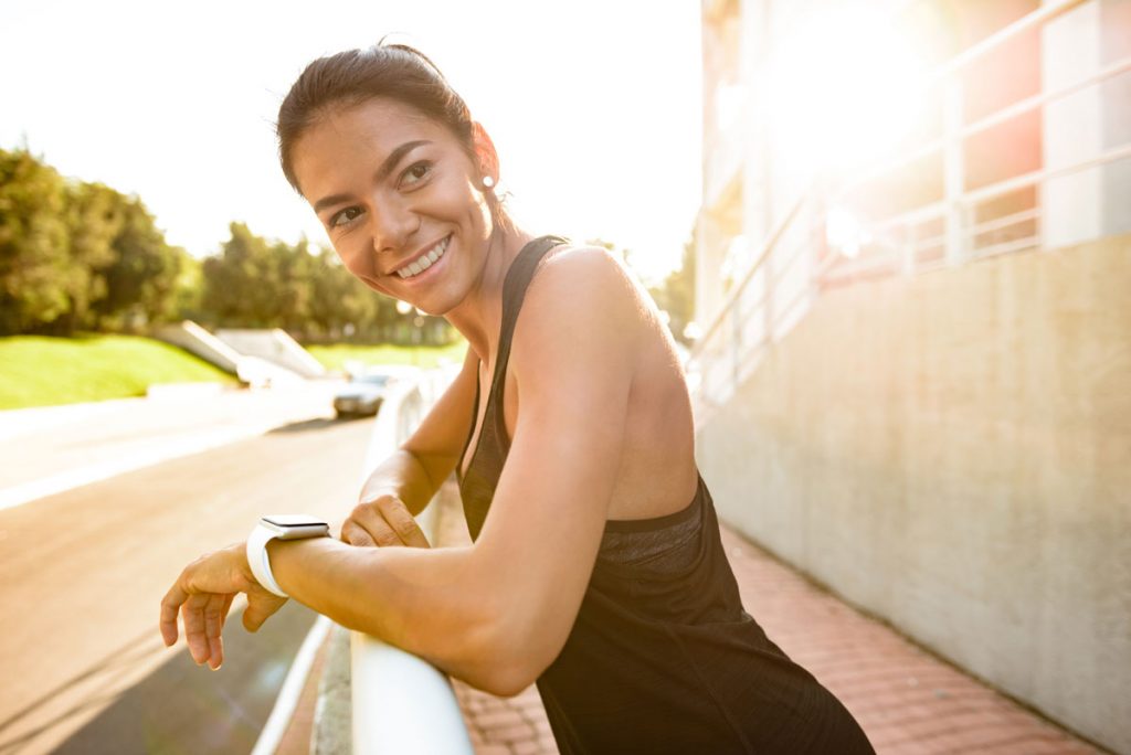 Mujer sonríe mientras practica ejercicio.