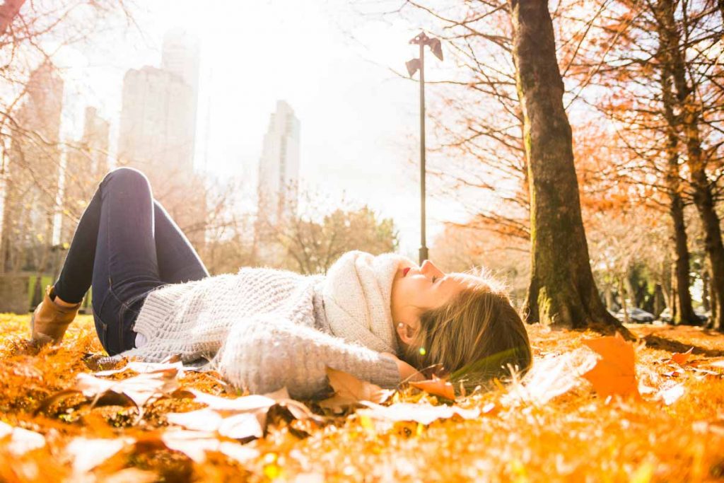 Mujer tomando el sol en otoño